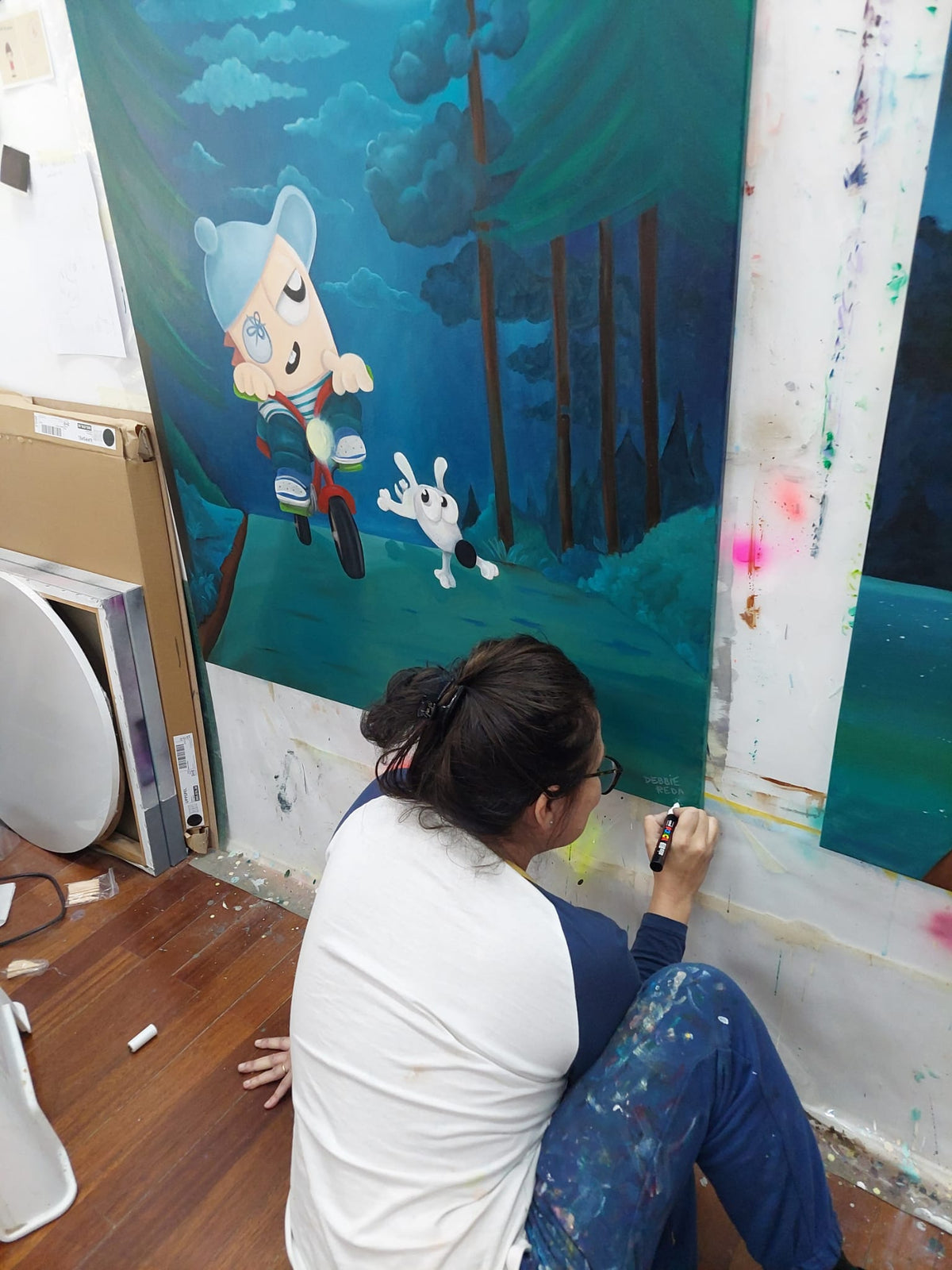 Debbie Reda signing a painting